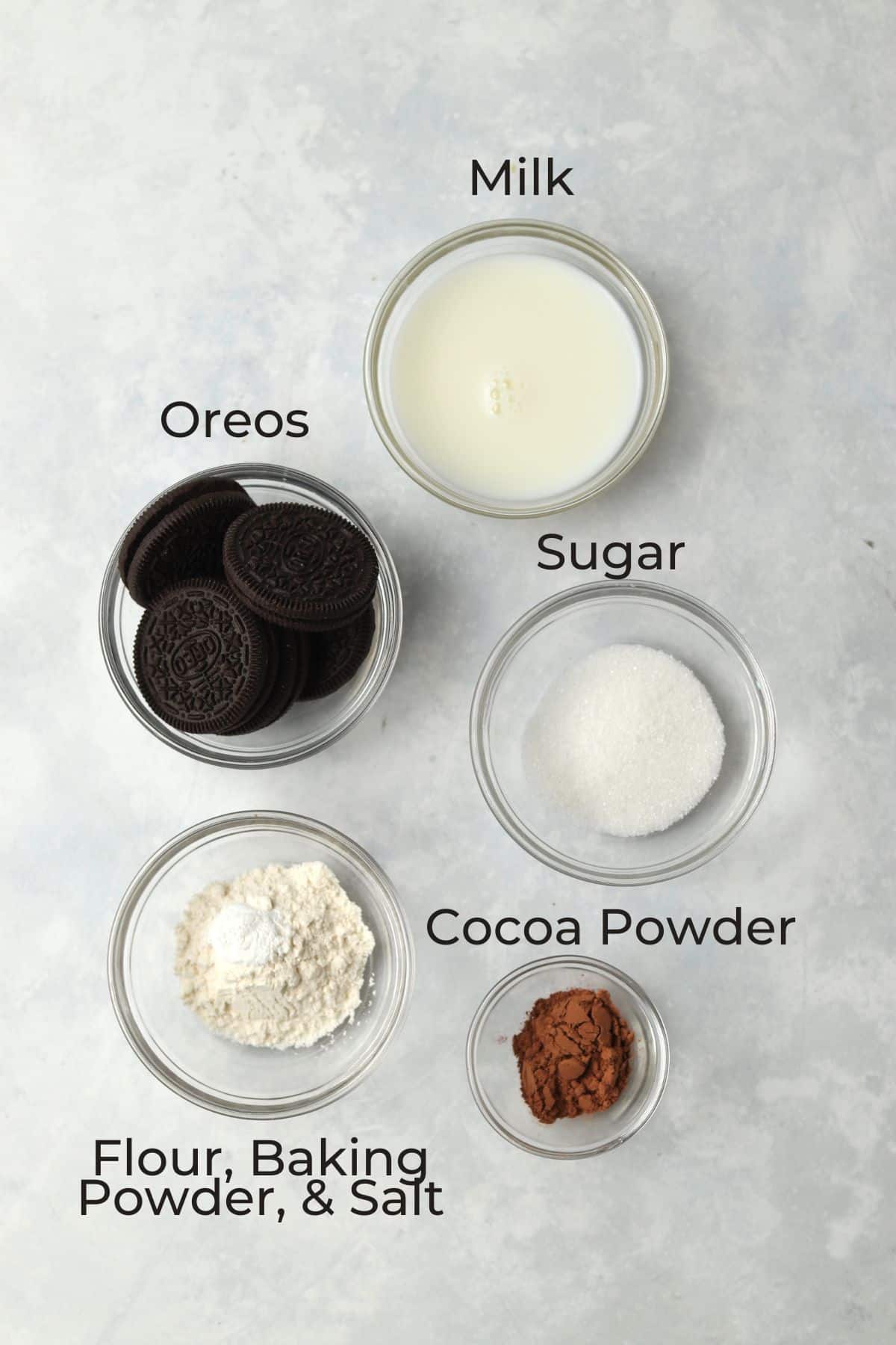 oreos, milk, sugar, flour, baking powder, salt, and cocoa powder in small bowls