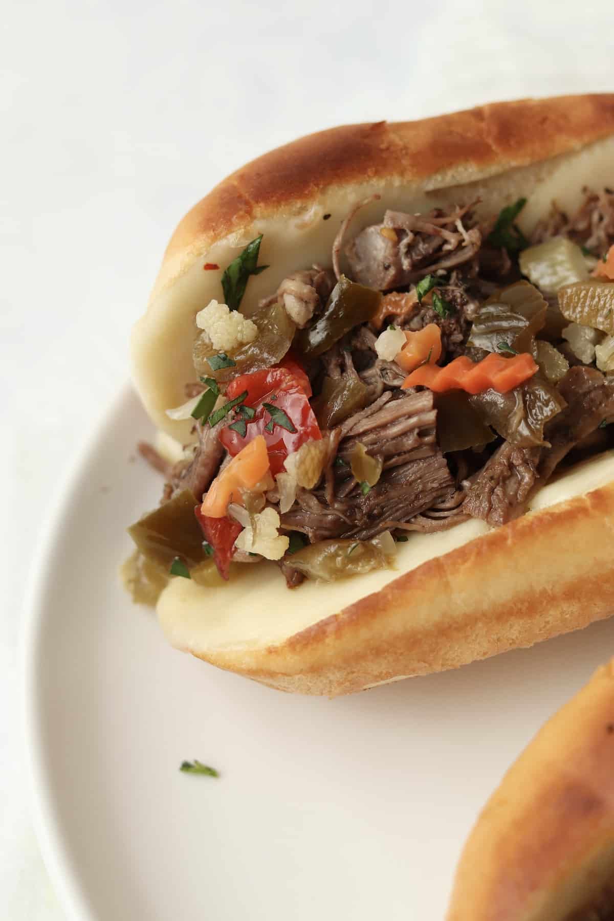close up of shredded beef in a hoagie bun with giardiniera
