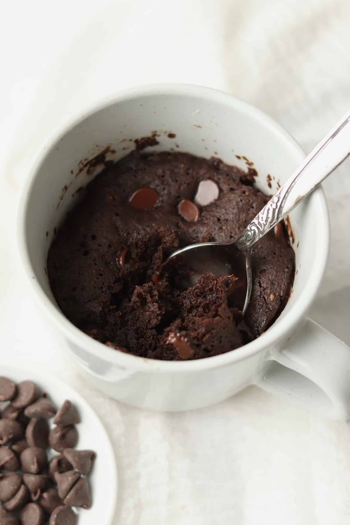 spoon in mug cake with extra chocolate chips
