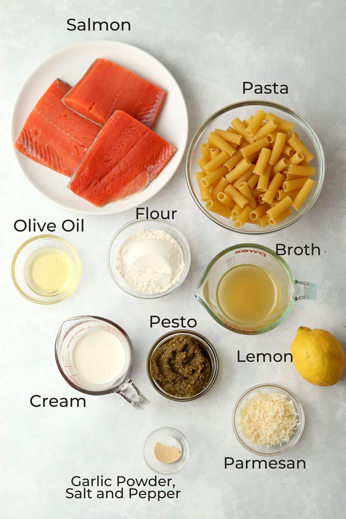 salmon, pasta, flour, broth, oil, pesto, cream, parmesan, lemon, and spices in glass prep bowls