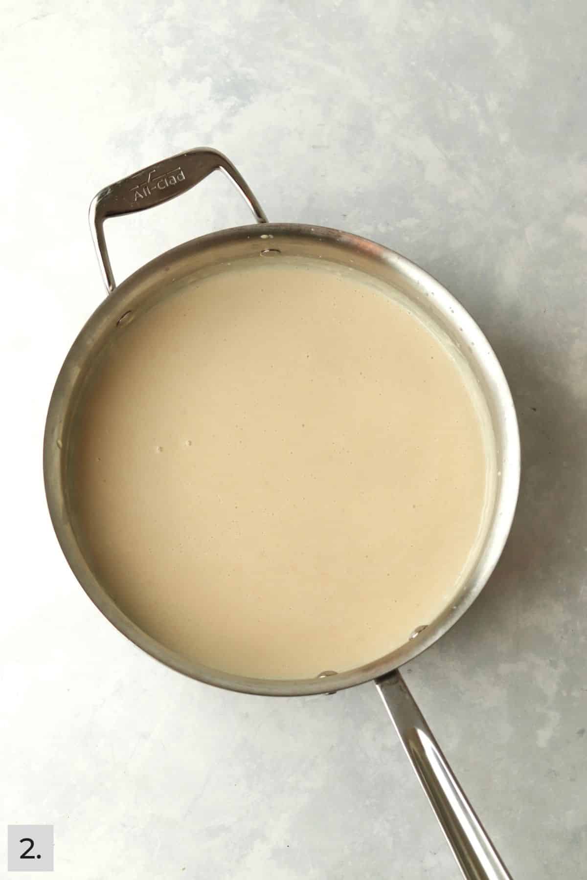 milk added to roux in sauté pan.