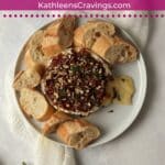 Baked brie with jam and pecans and bread slices.