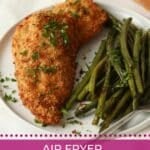 Parmesan crusted chicken on a plate with green beans.