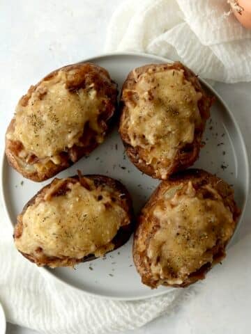 Loaded French onion baked potatoes on a plate.
