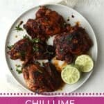 Chili lime chicken thighs on a plate with lime halves.
