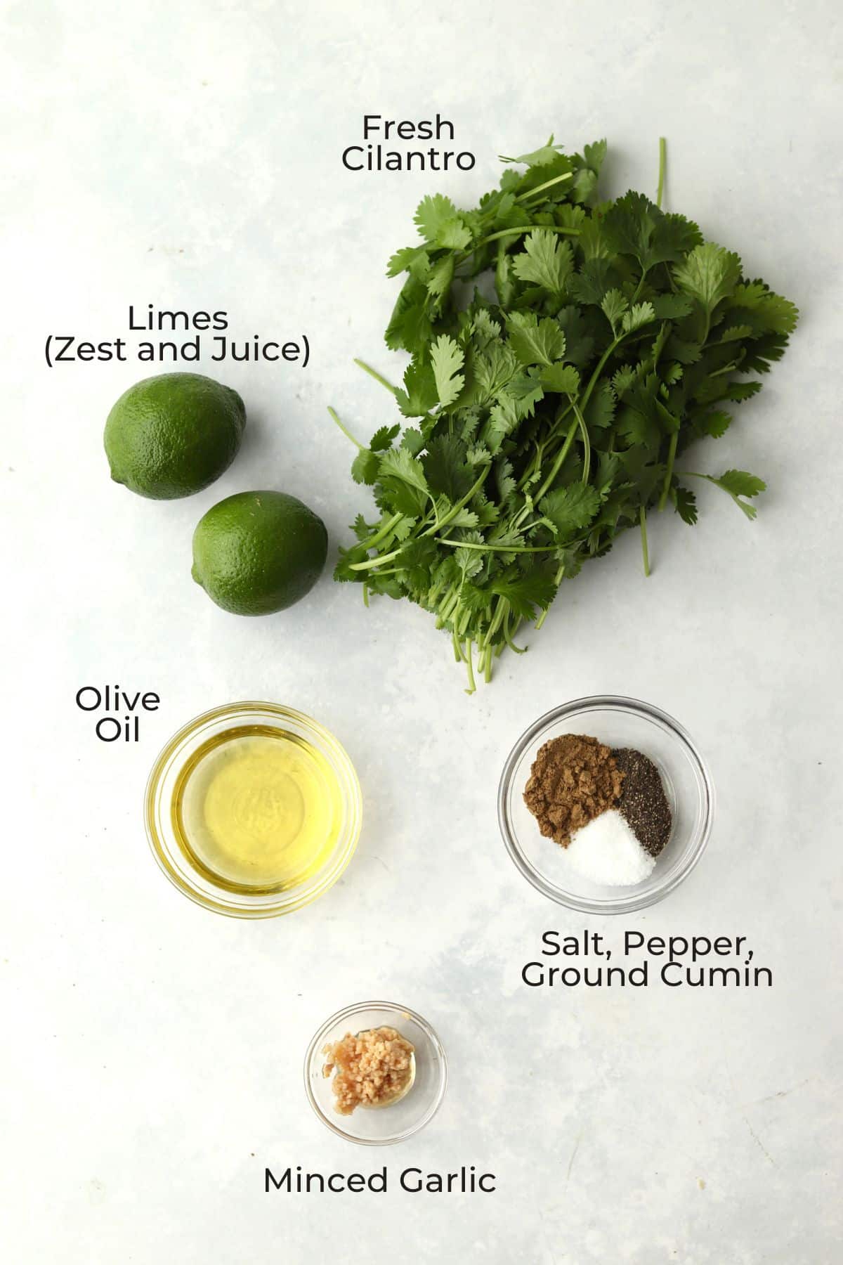 Cilantro, limes, oil, spices, and garlic in prep bowls.