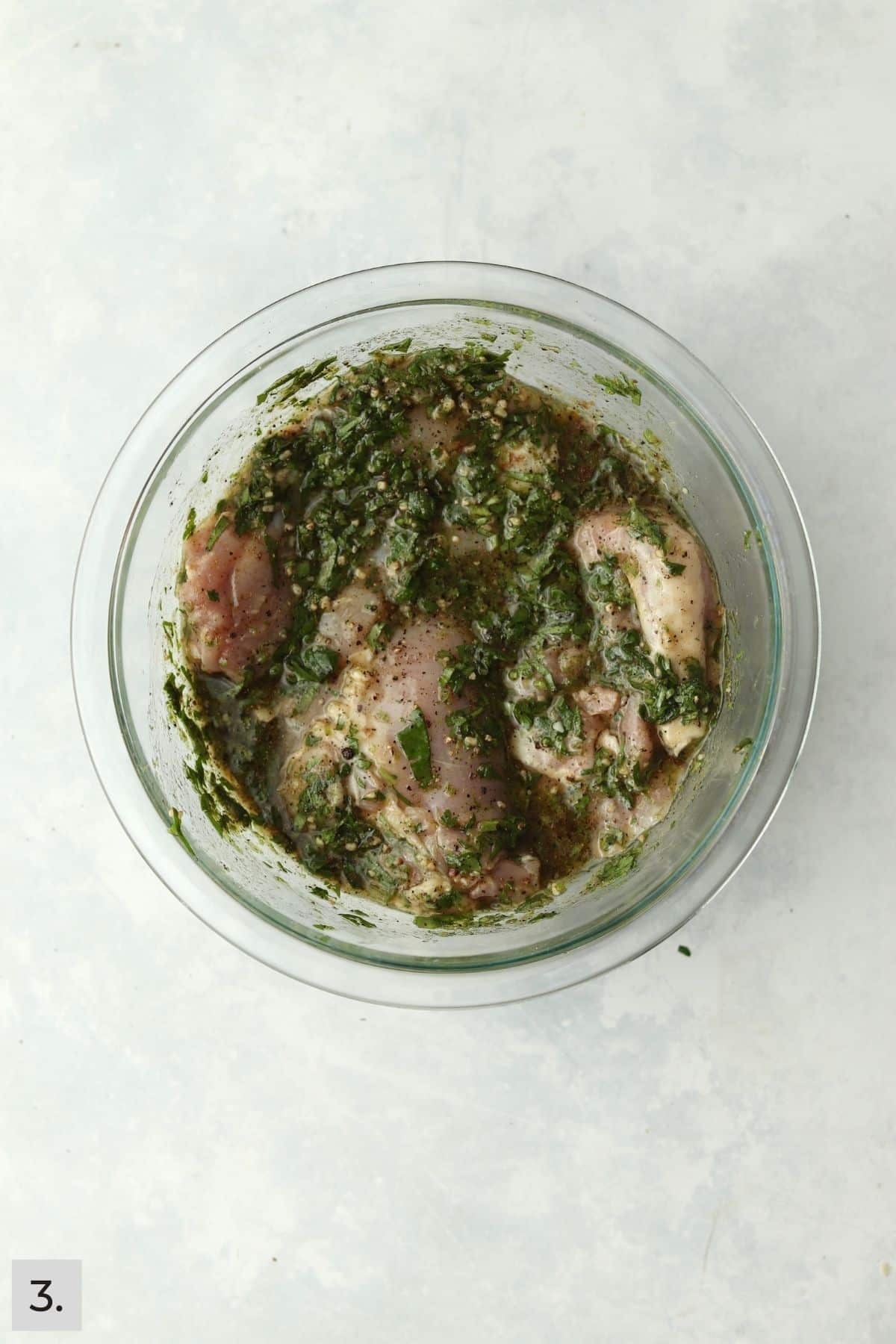 Chicken things in cilantro lime marinade in bowl.