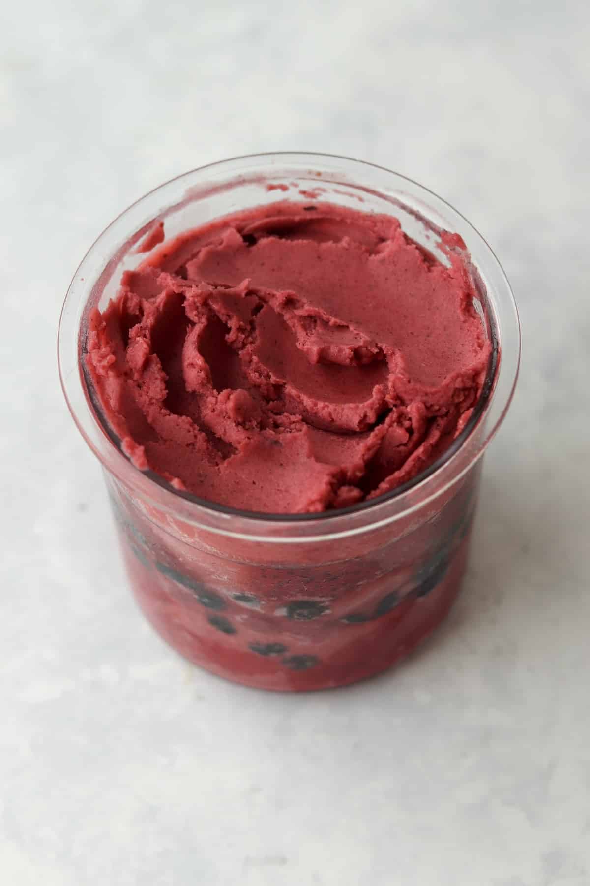 Mixed berry sorbet in the Ninja Creami plastic pint container.