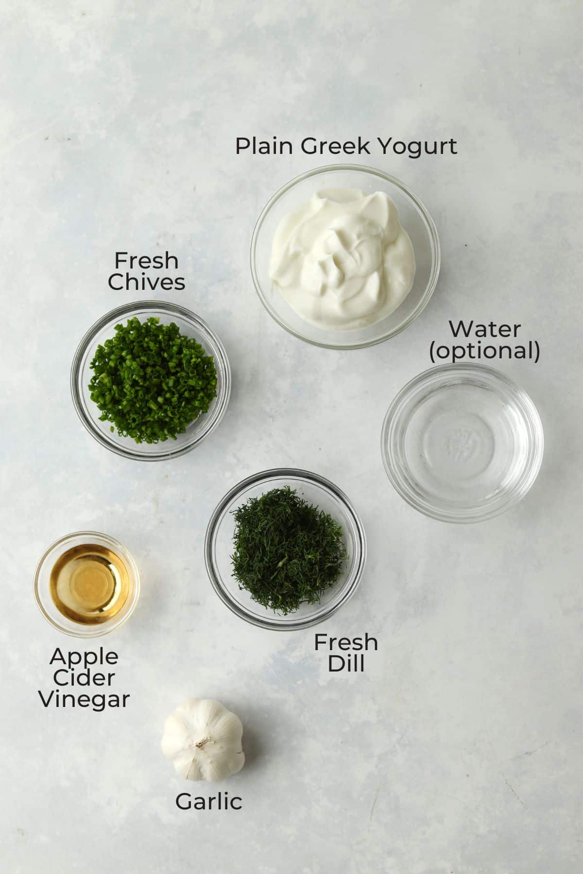 Greek yogurt, dill, chives, garlic, apple cider vinegar, and water in small prep bowls.