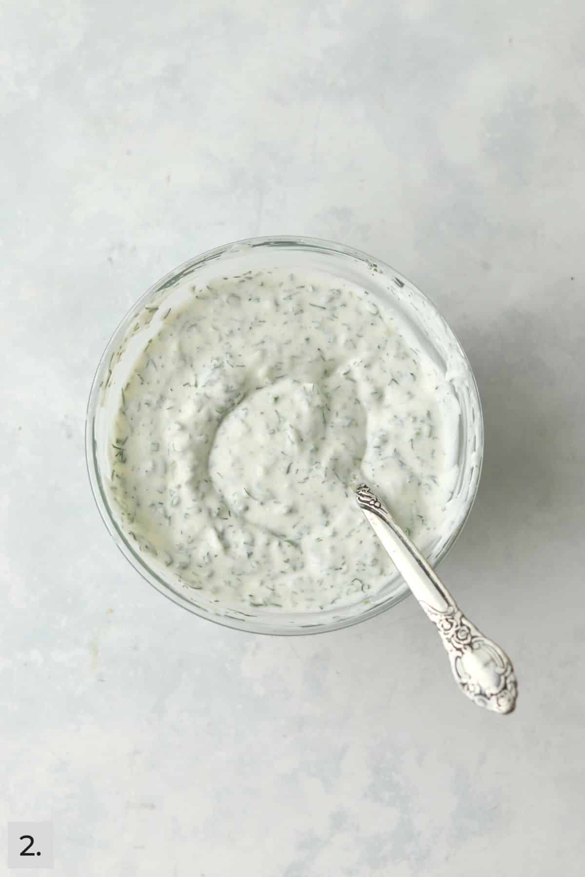 Greek yogurt ranch dressing in a bowl with a spoon.