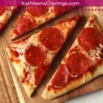 Blackstone flatbread pizza with pepperoni on a wooden cutting board.