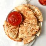 Plate of pizza quesadillas with marinara and pepperoni.