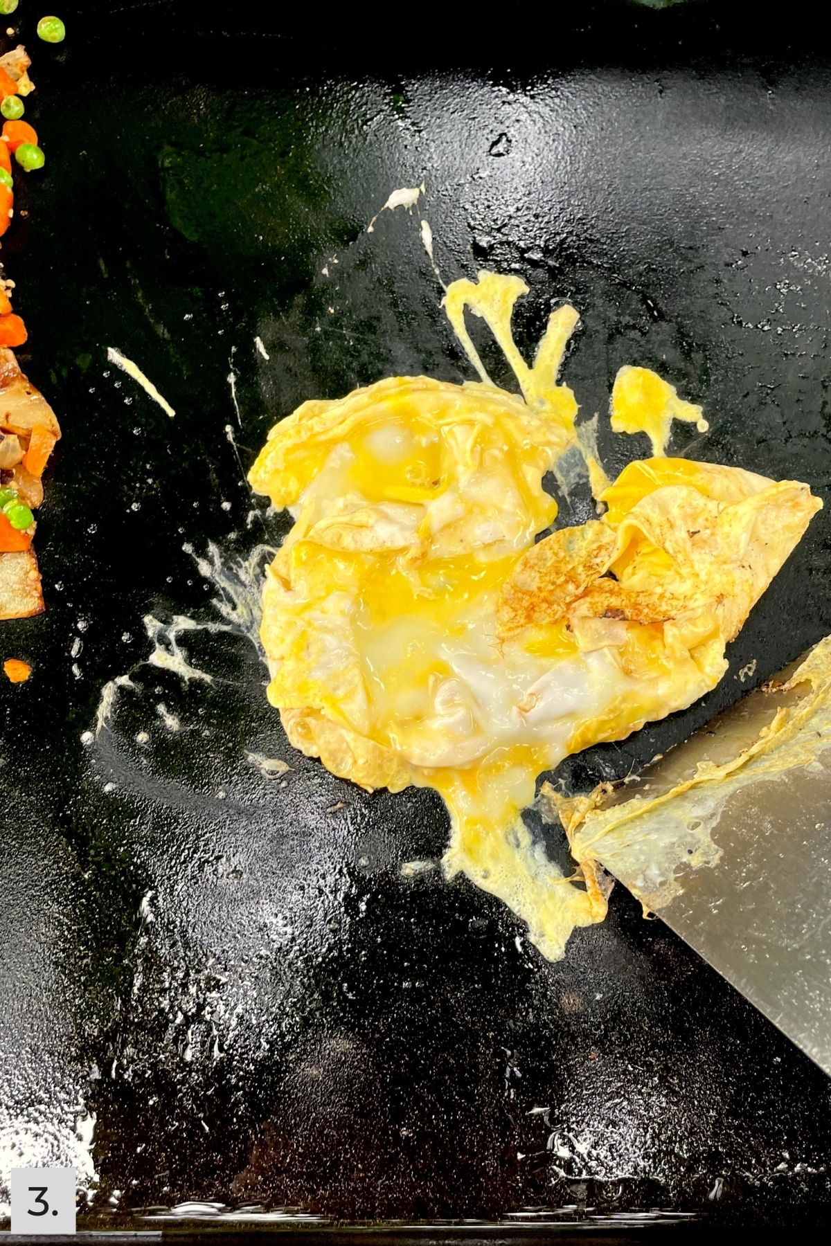 Beaten eggs being scrambled on the Blackstone griddle.