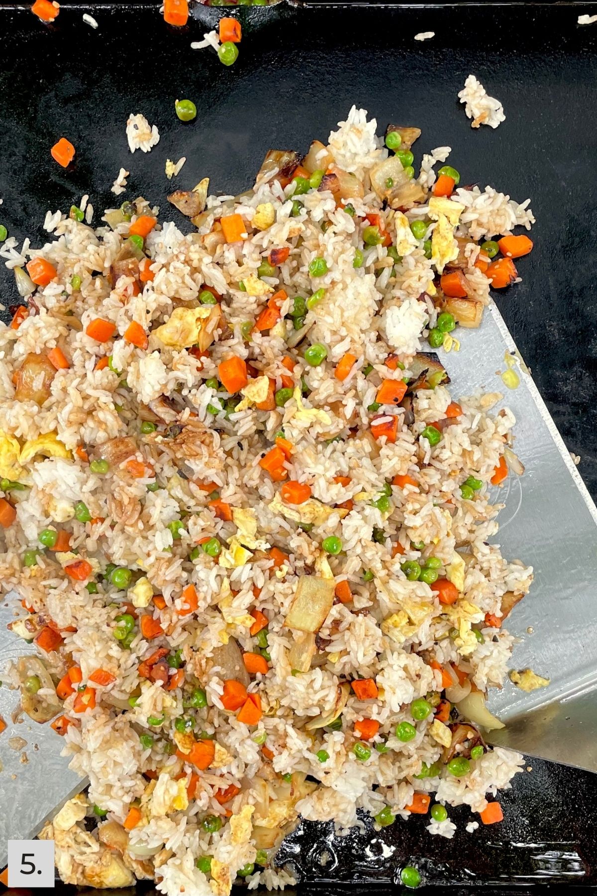 Cooked peas, carrots, and onions tossed with fried white rice.