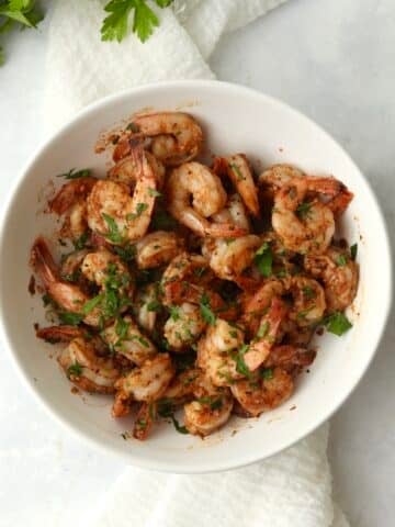 Blackstone cajun shrimp in a bowl with fresh parsley.