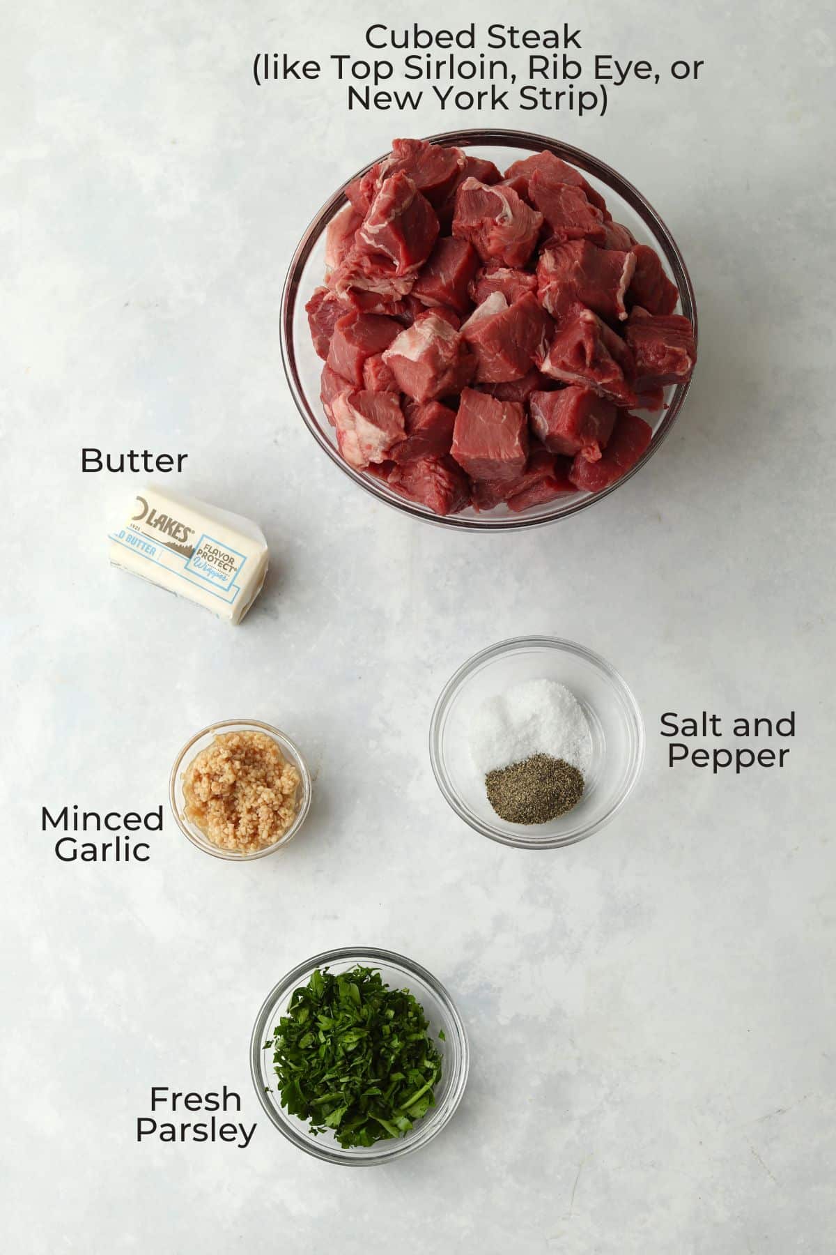 Cubed steak, butter, garlic, parsley, and salt/pepper in prep bowls.