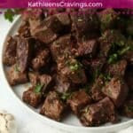 Plate of Blackstone Garlic Butter Steak Bites with parsley.