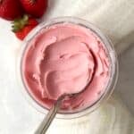 Ninja Creami Strawberry Frozen Yogurt in the pint container with fresh strawberries.