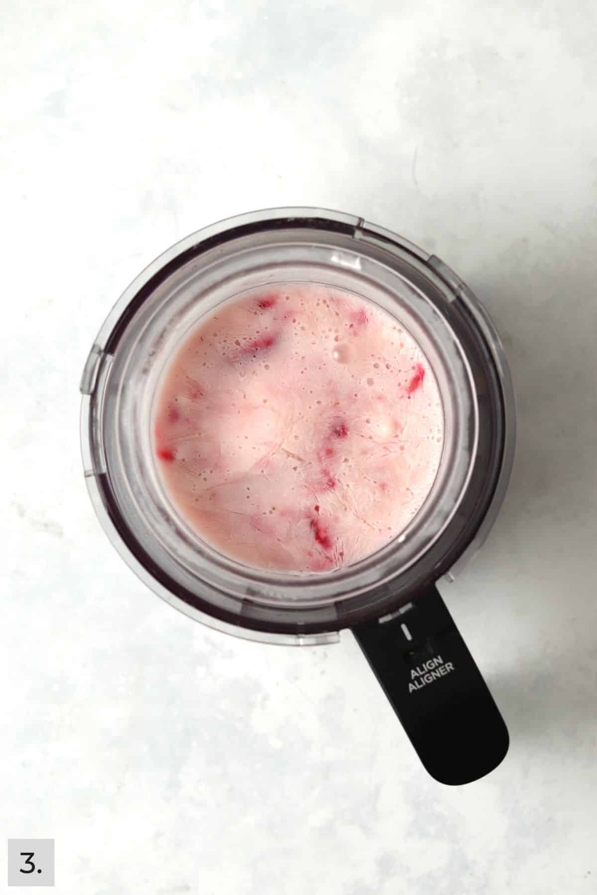 Frozen strawberry Greek yogurt mixture in the Ninja Creami.