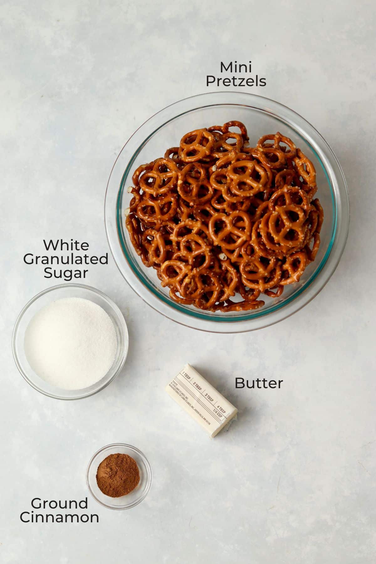 Bowl of pretzels, sugar, cinnamon, and half a stick of butter.