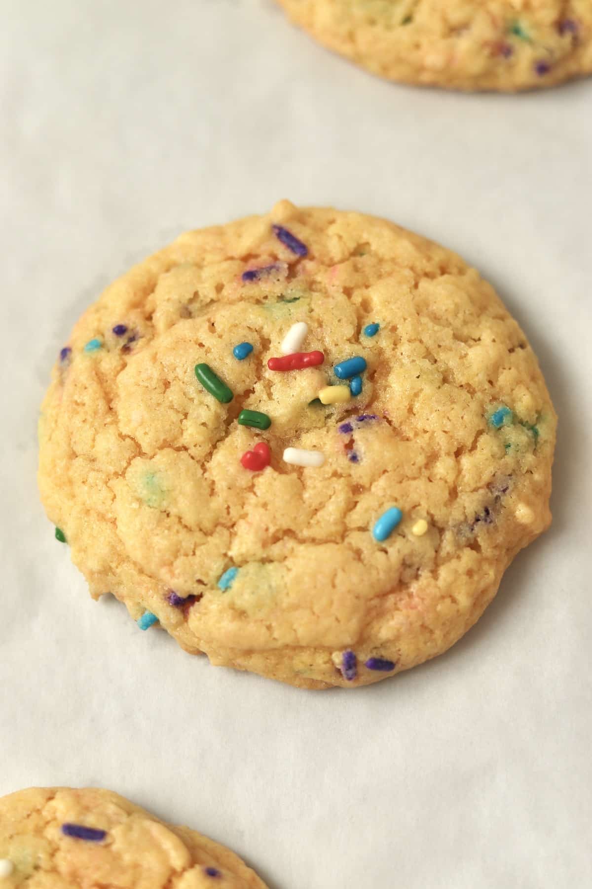 close up of funfetti cake mix cookie on parchment paper.