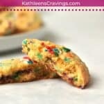 One funfetti cookie broken in half to show sprinkle-filled inside.