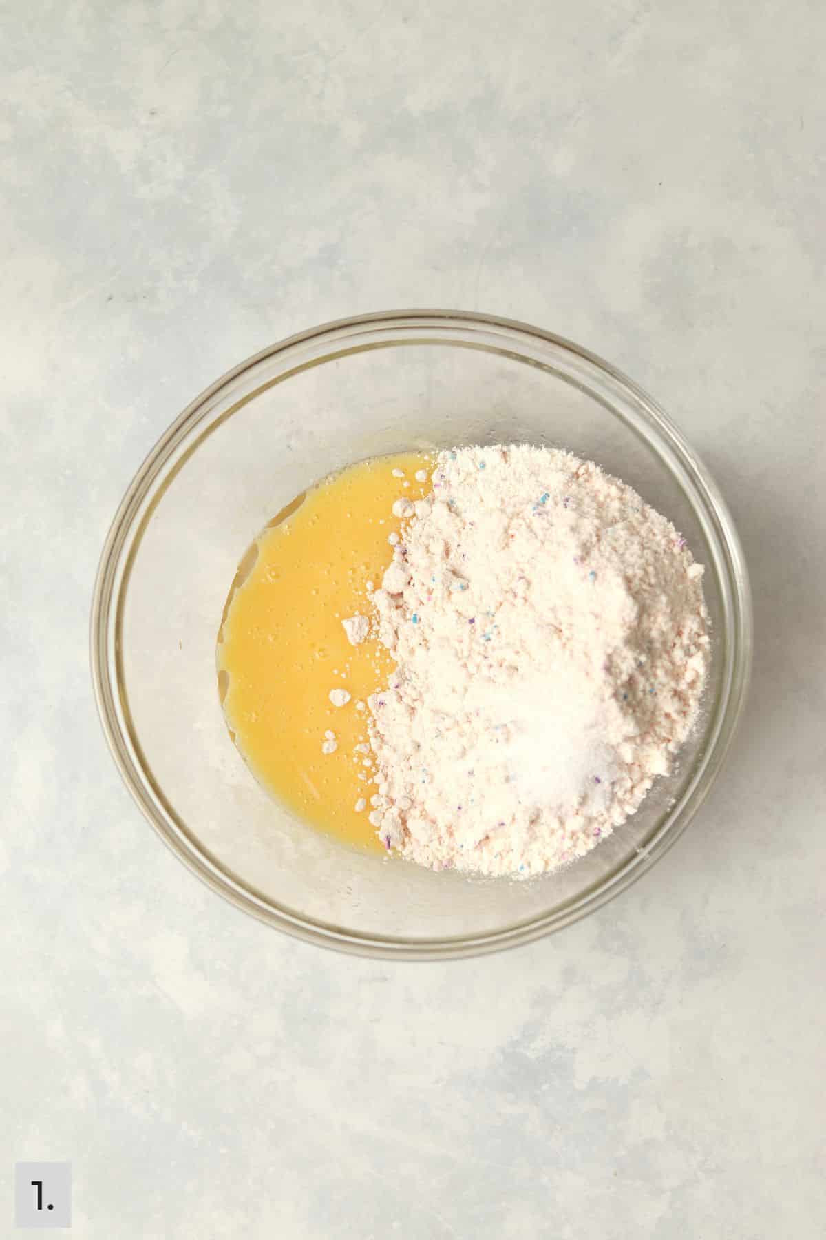 Eggs and oil mixed together with funfetti cake mix being added.