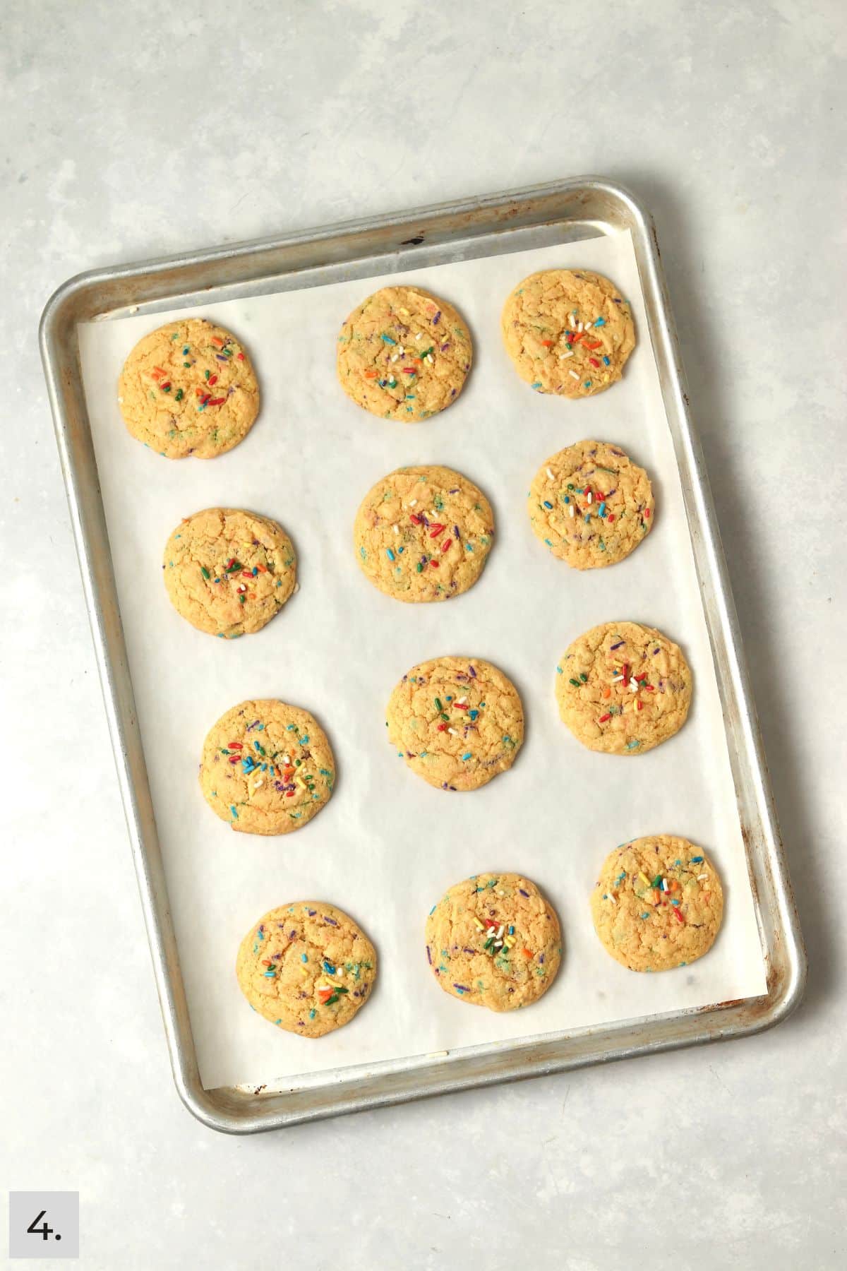 Baked funfetti cake mix cookies on a sheet pan.