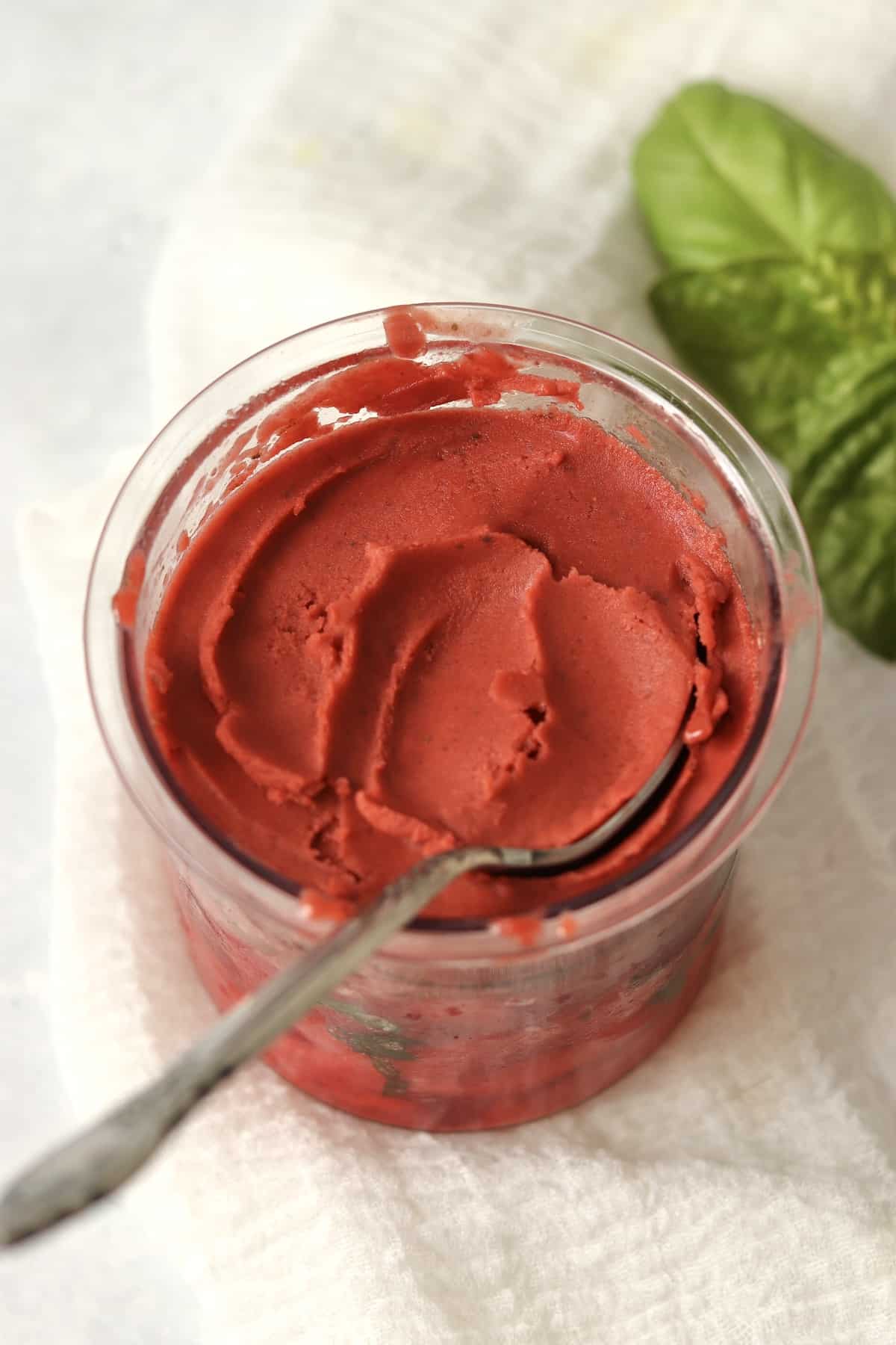 Ninja Creami Strawberry Basil Sorbet in the pint container with a spoon.