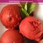 Scoops of Ninja Creami Strawberry Basil Sorbet in a bowl with fresh basil leaves.