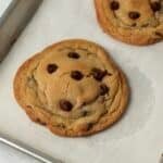 Single serve chocolate chip cookies on a baking sheet.