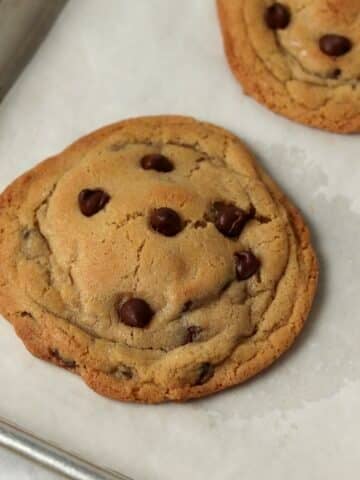 Single serve chocolate chip cookies on a baking sheet.