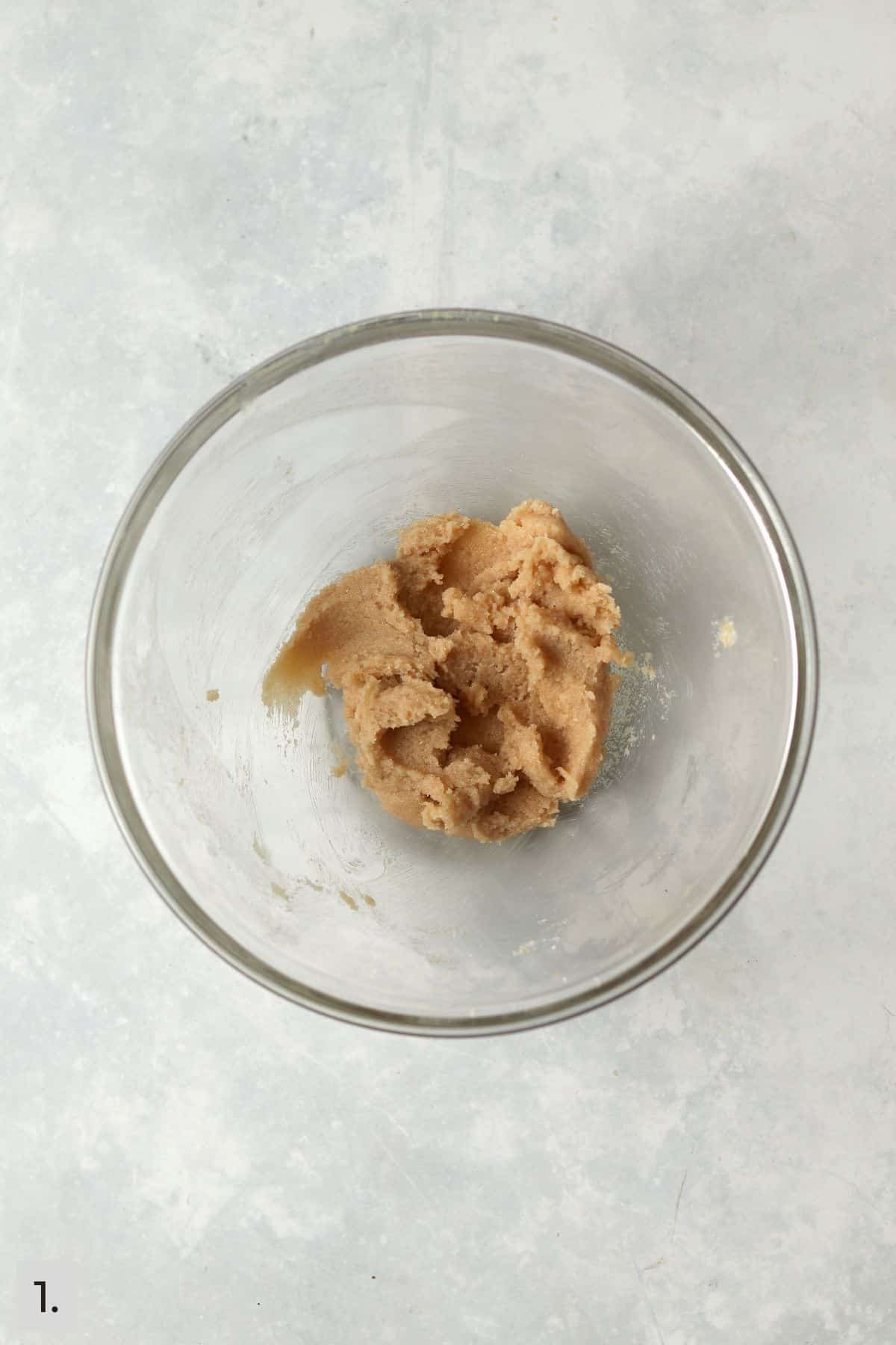 Creamed brown sugar, white sugar, and softened butter in a glass bowl.