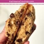 Single serve oatmeal chocolate chip cookie broken in half to show gooey inside.