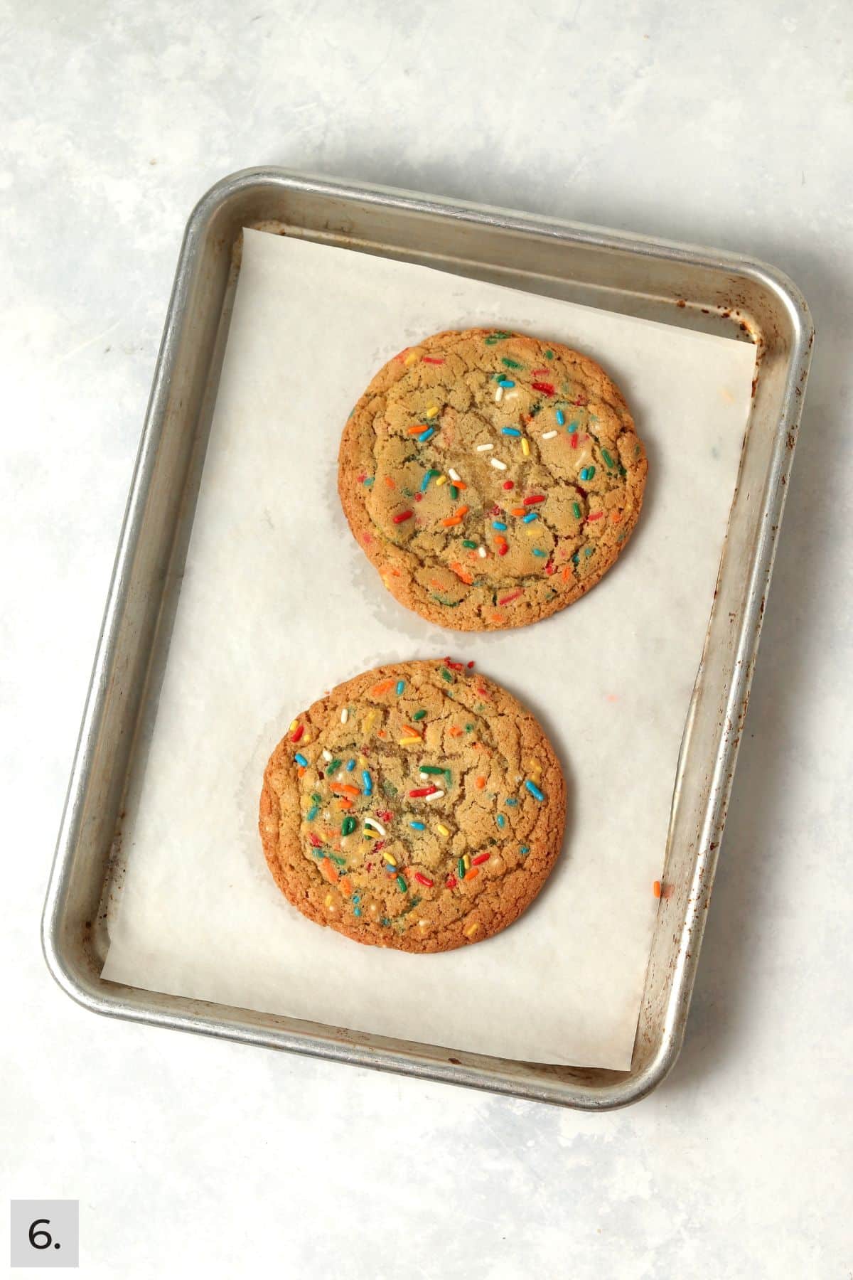 Baked single serve sugar cookies on a baking sheet.