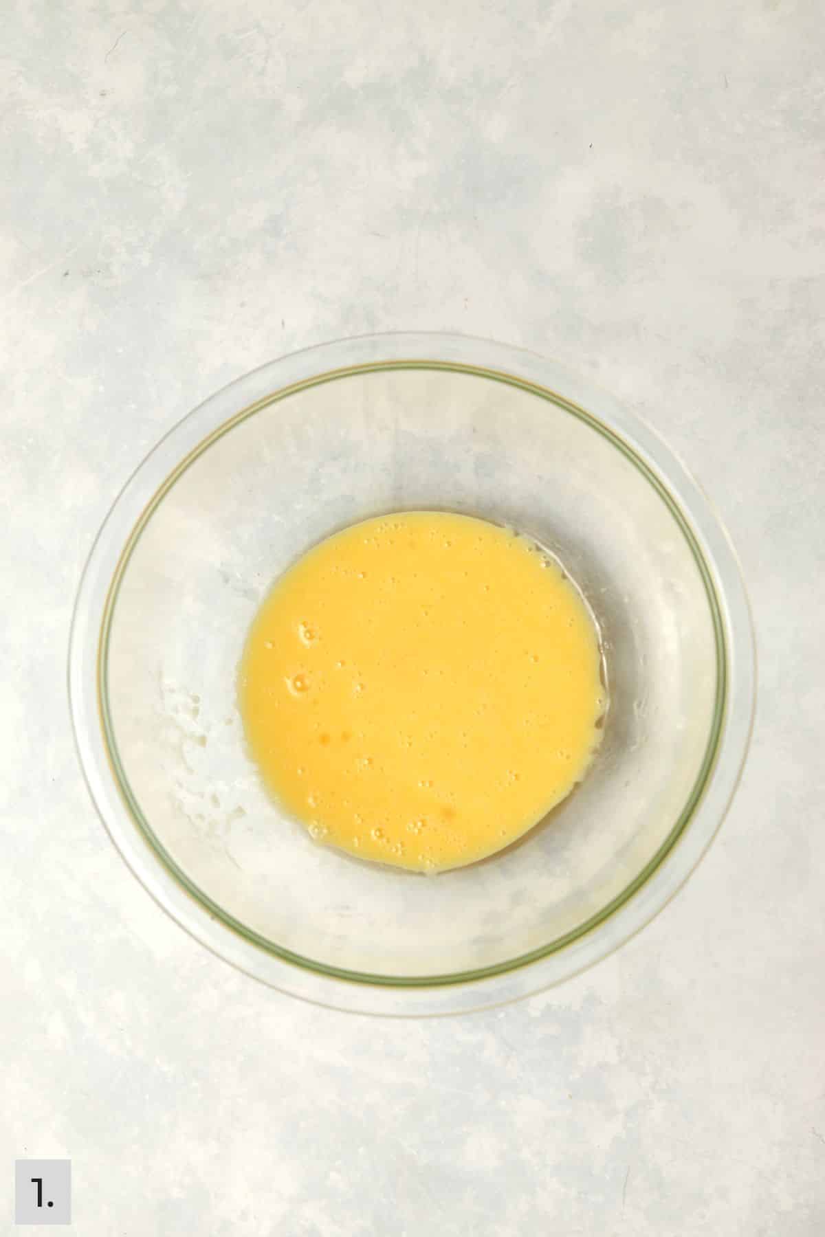 Eggs and oil beaten in a bowl.