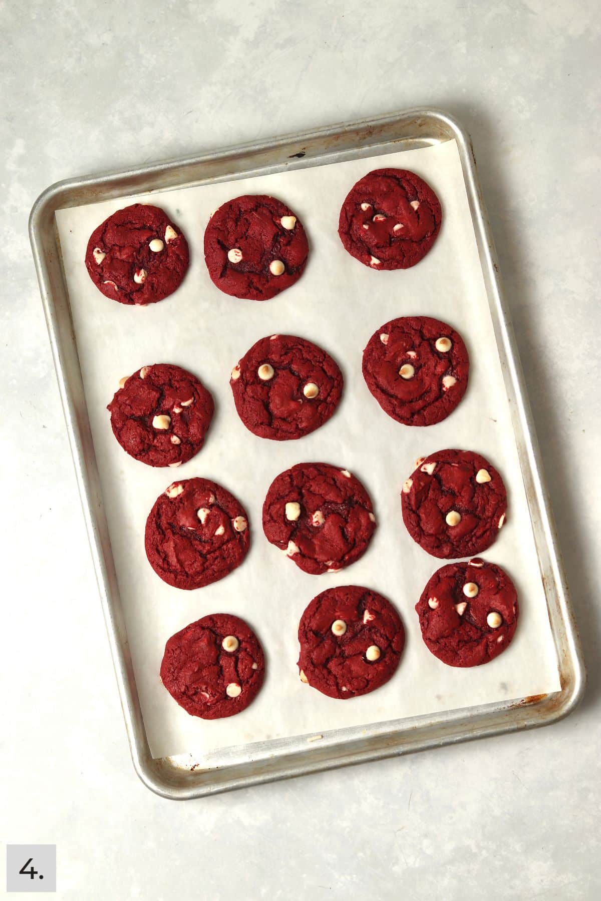 Baked red velvet cake mix cookies on a baking sheet.