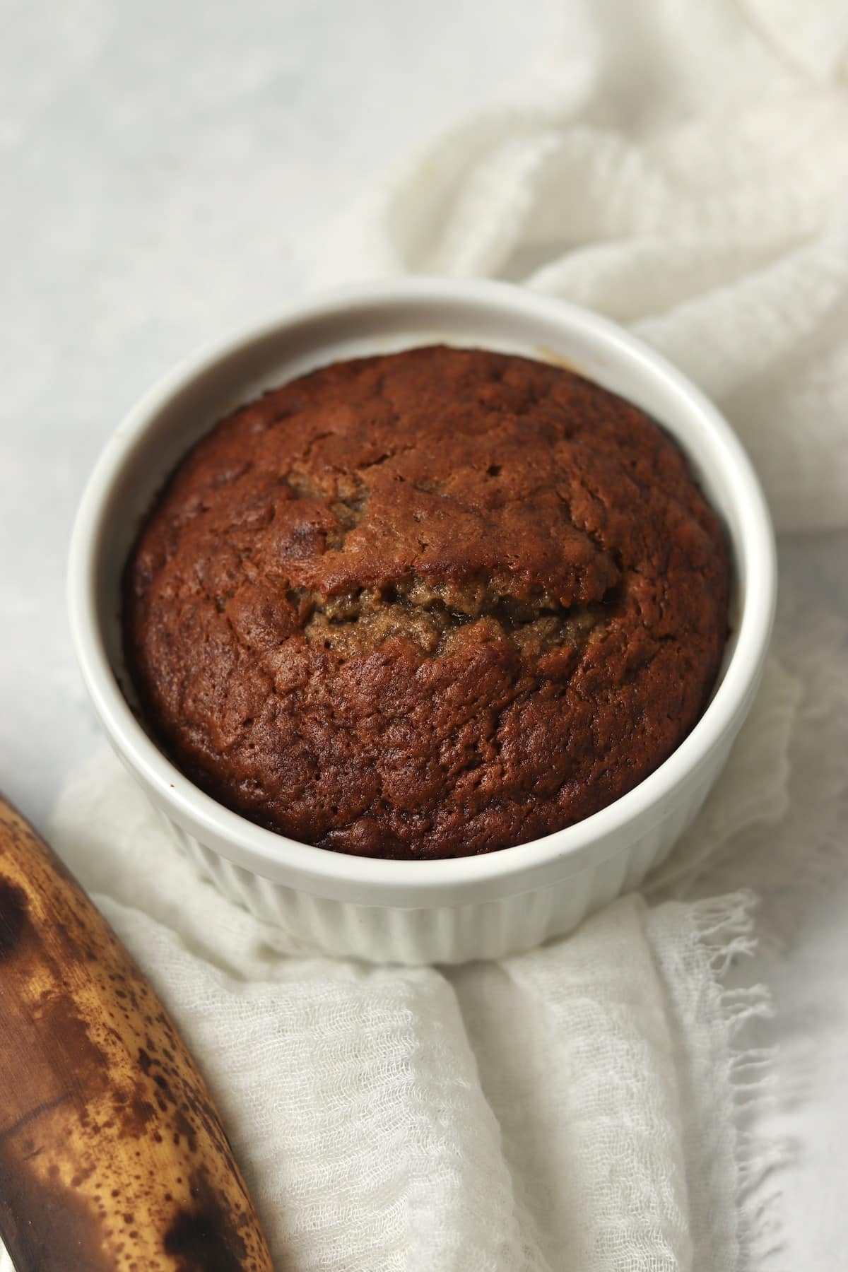 Single serve banana bread in a ramekin with 1 ripe banana.