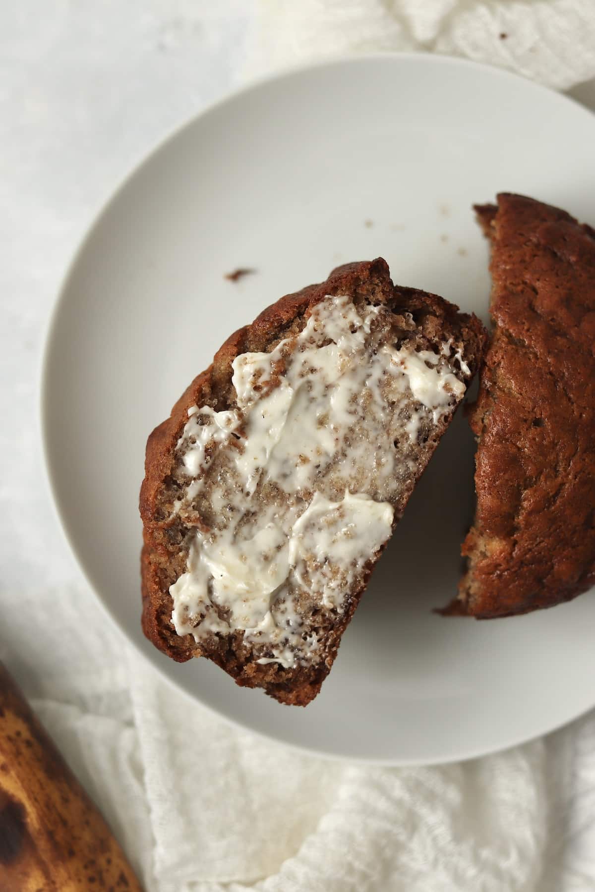 Small banana bread cut in half and slathered in butter.