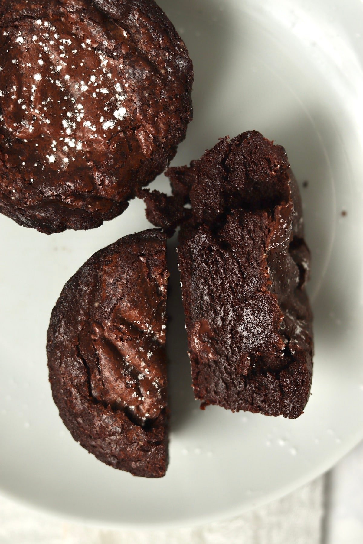 Single serve brownie on a plate cut in half to show fudgy center.