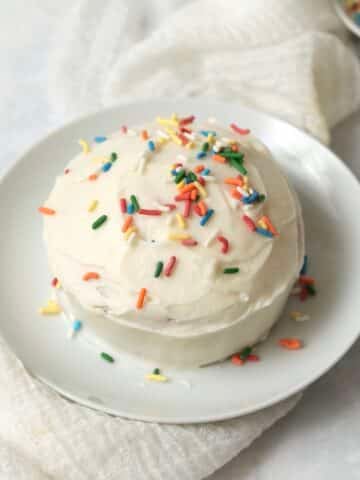 Single serve cake with frosting on a plate.