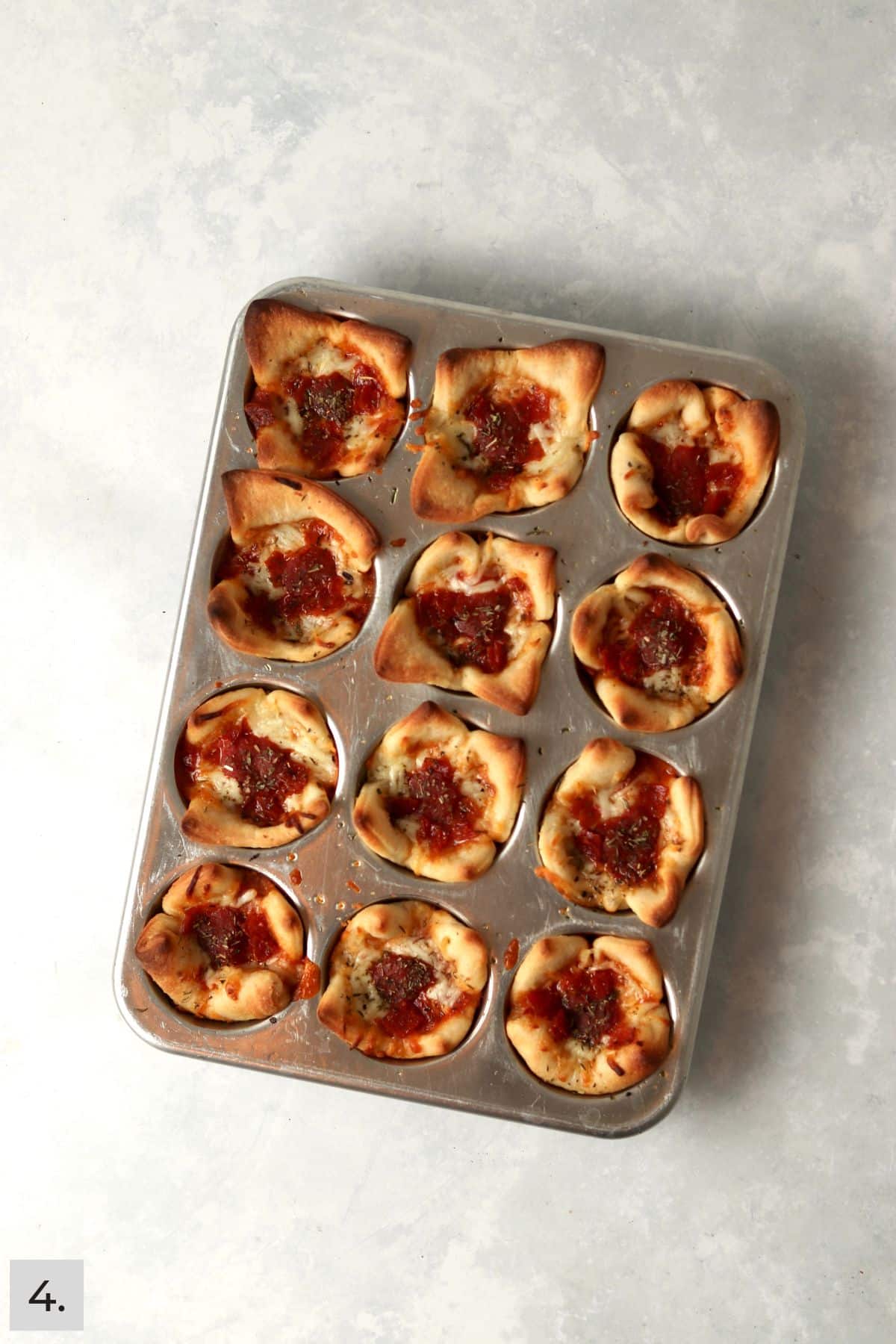 Baked pizza cups in a muffin pan.