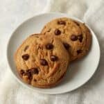 Two brown butter chocolate chip cookies on a plate.