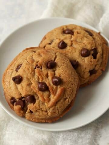 Two brown butter chocolate chip cookies on a plate.