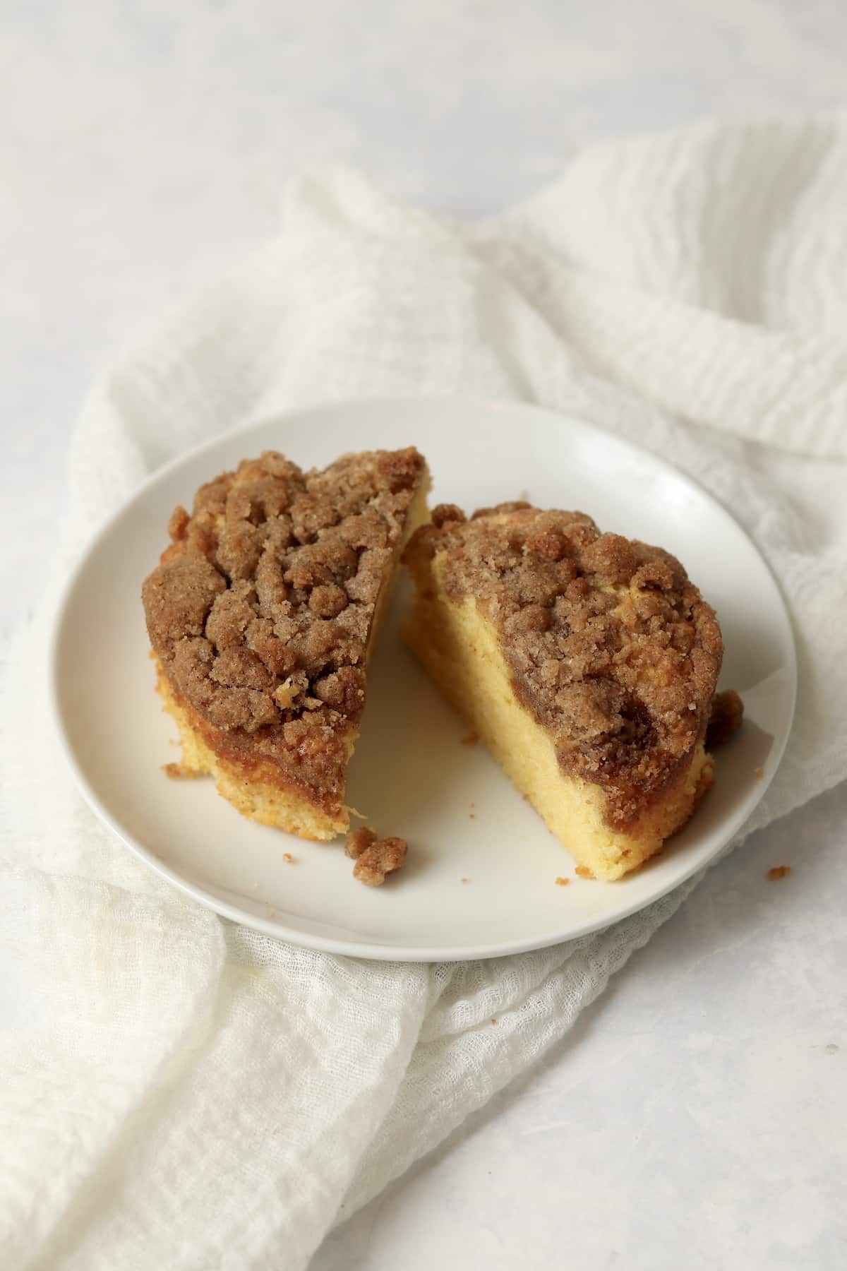 Small batch streusel coffee cake cut in half on a plate.