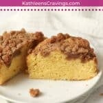 Single serve streusel coffee cake cut in half on a plate.