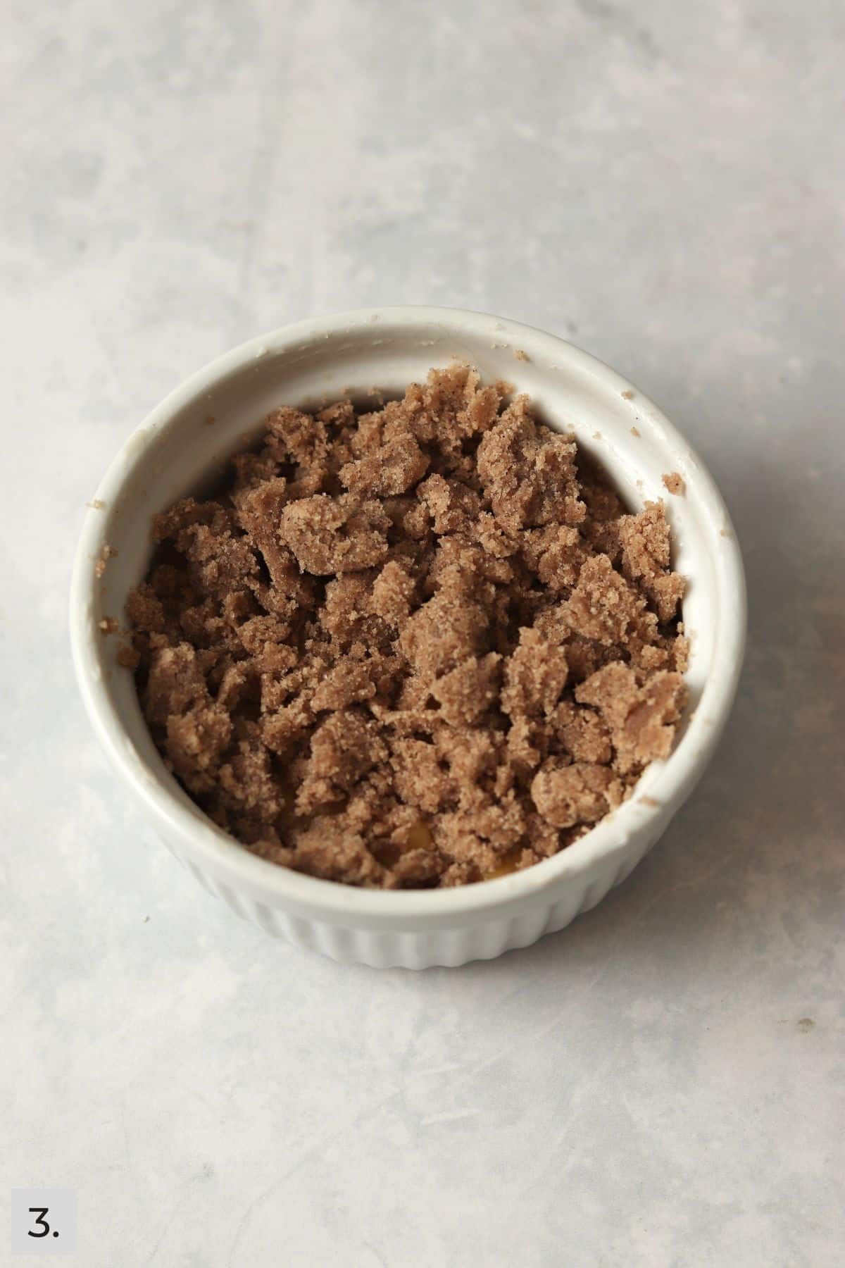 Unbaked coffee cake with streusel topping in a large ramekin.