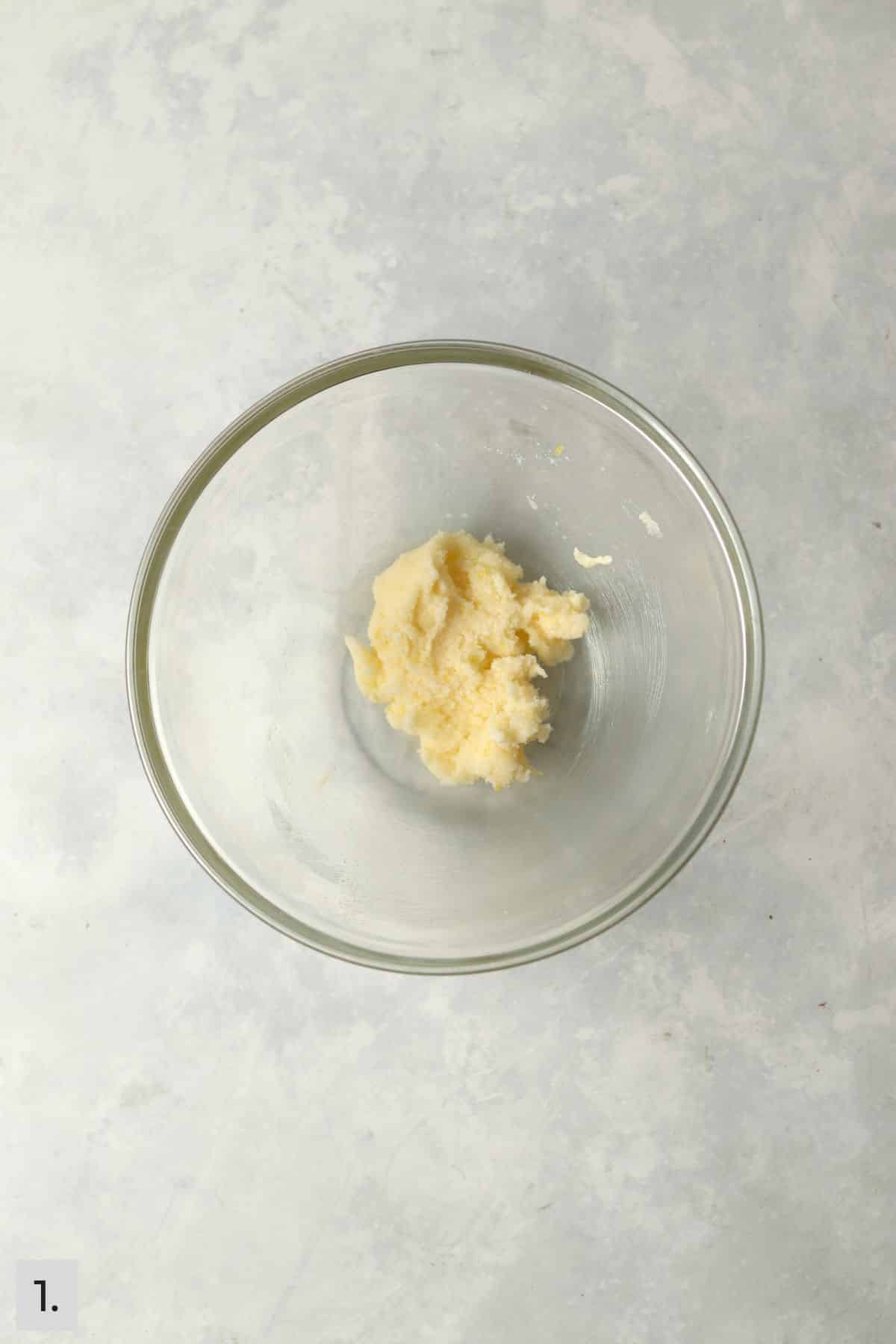 Small amounts of butter and sugar creamed in a bowl.
