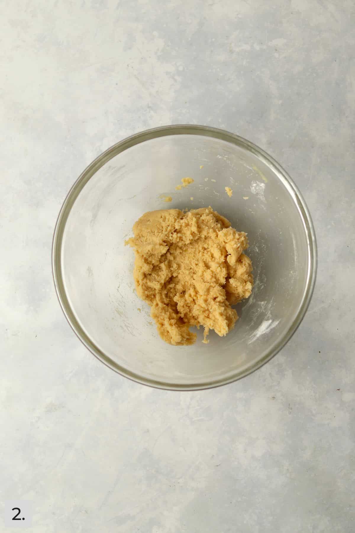 small batch of lemon cookie dough in a glass bowl.