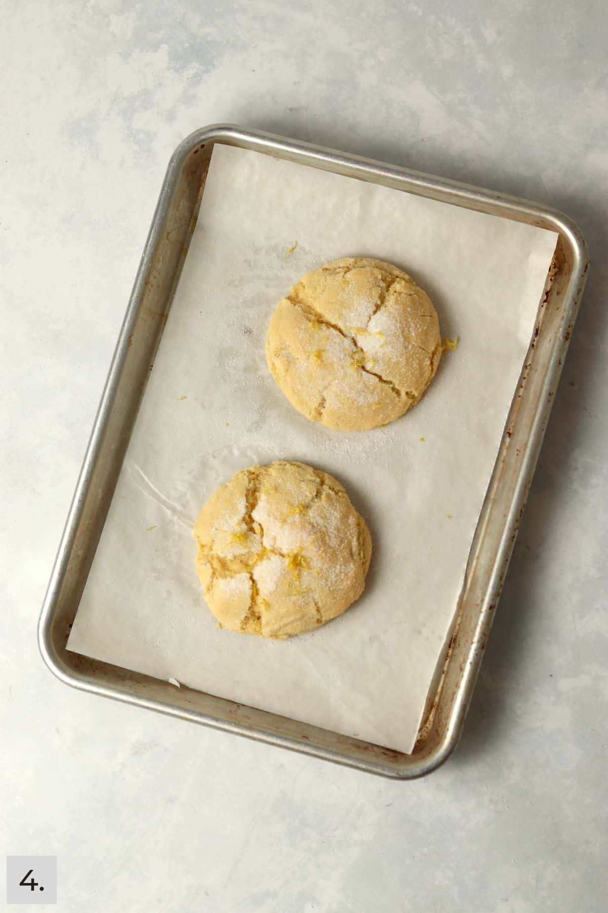 Two lemon cookies on a baking sheet.
